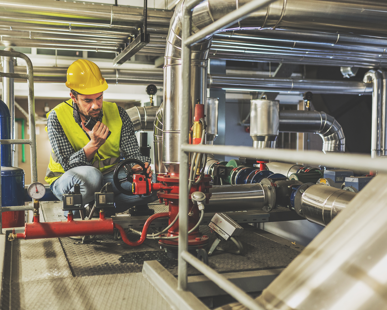 Engineer inspecting industrial pipes and machinery.