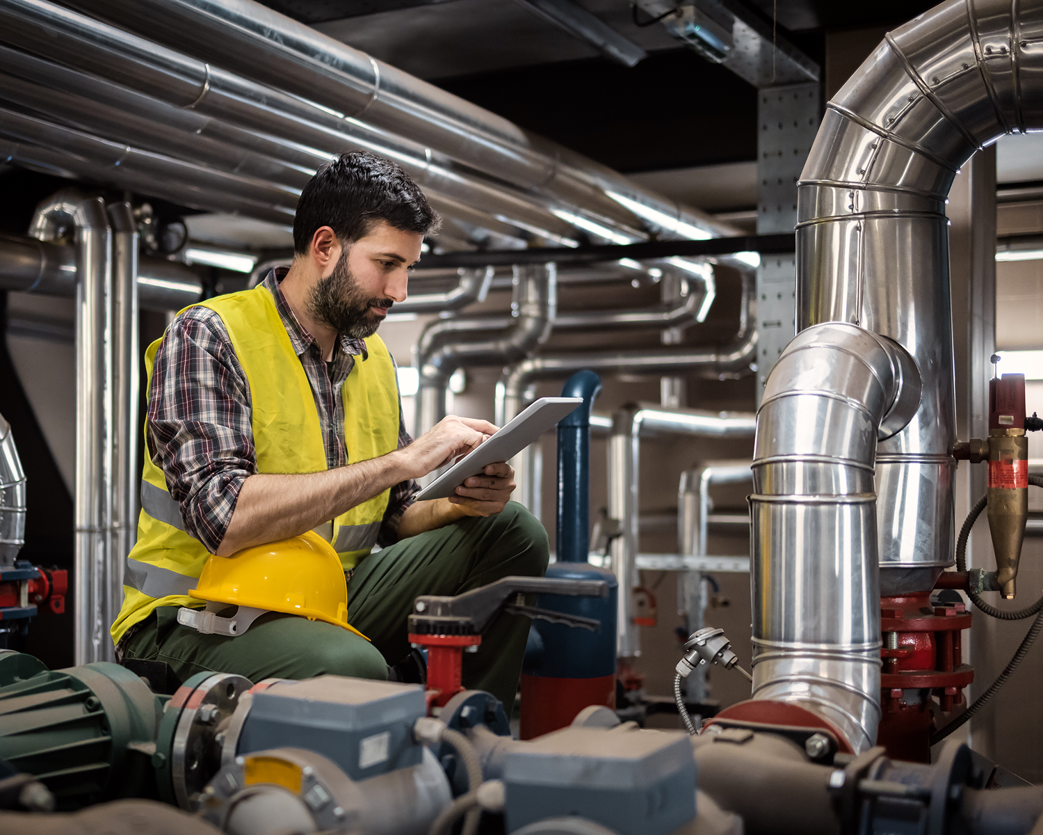Worker using tablet in industrial setting.