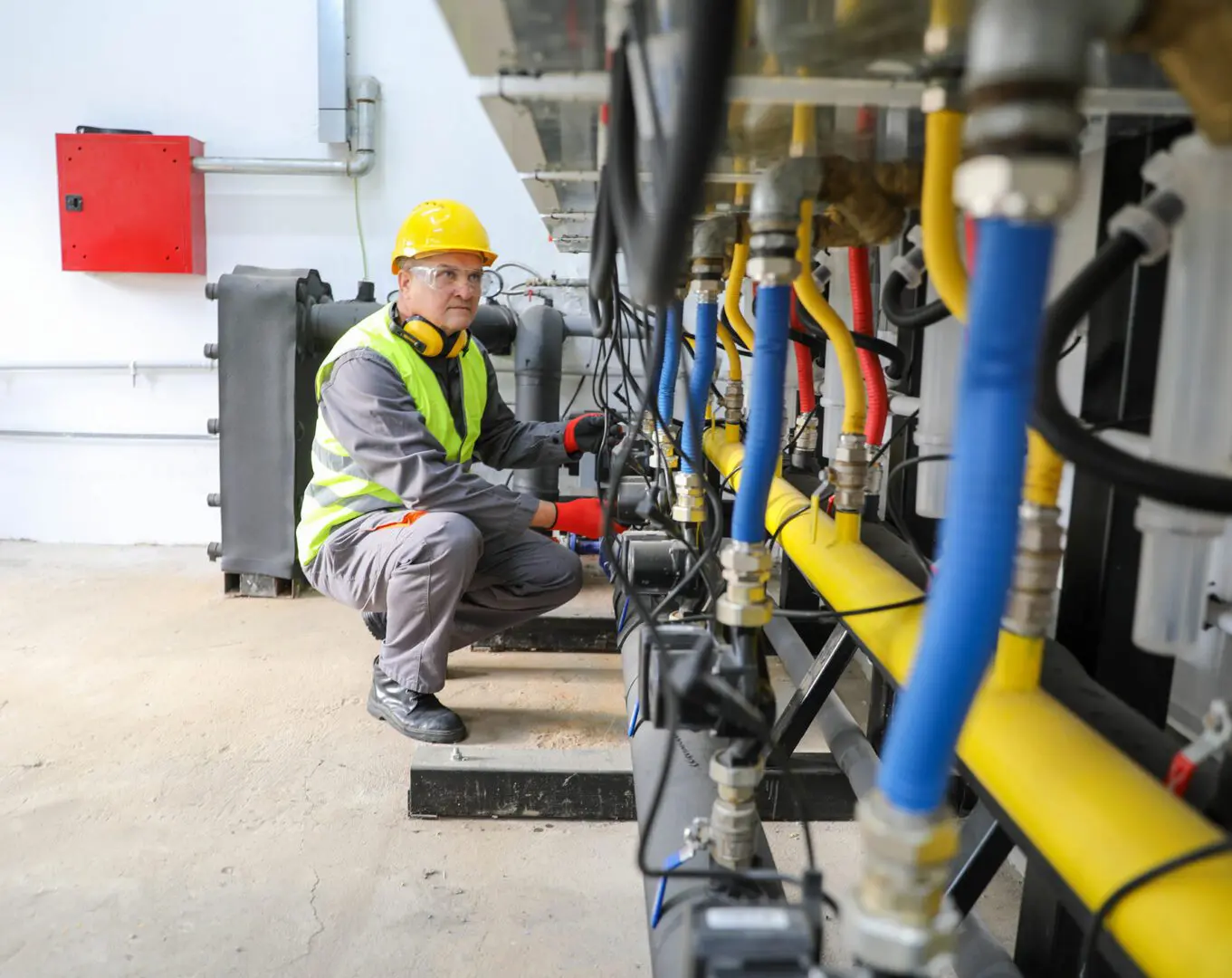 Engineer inspecting industrial machinery and pipes.