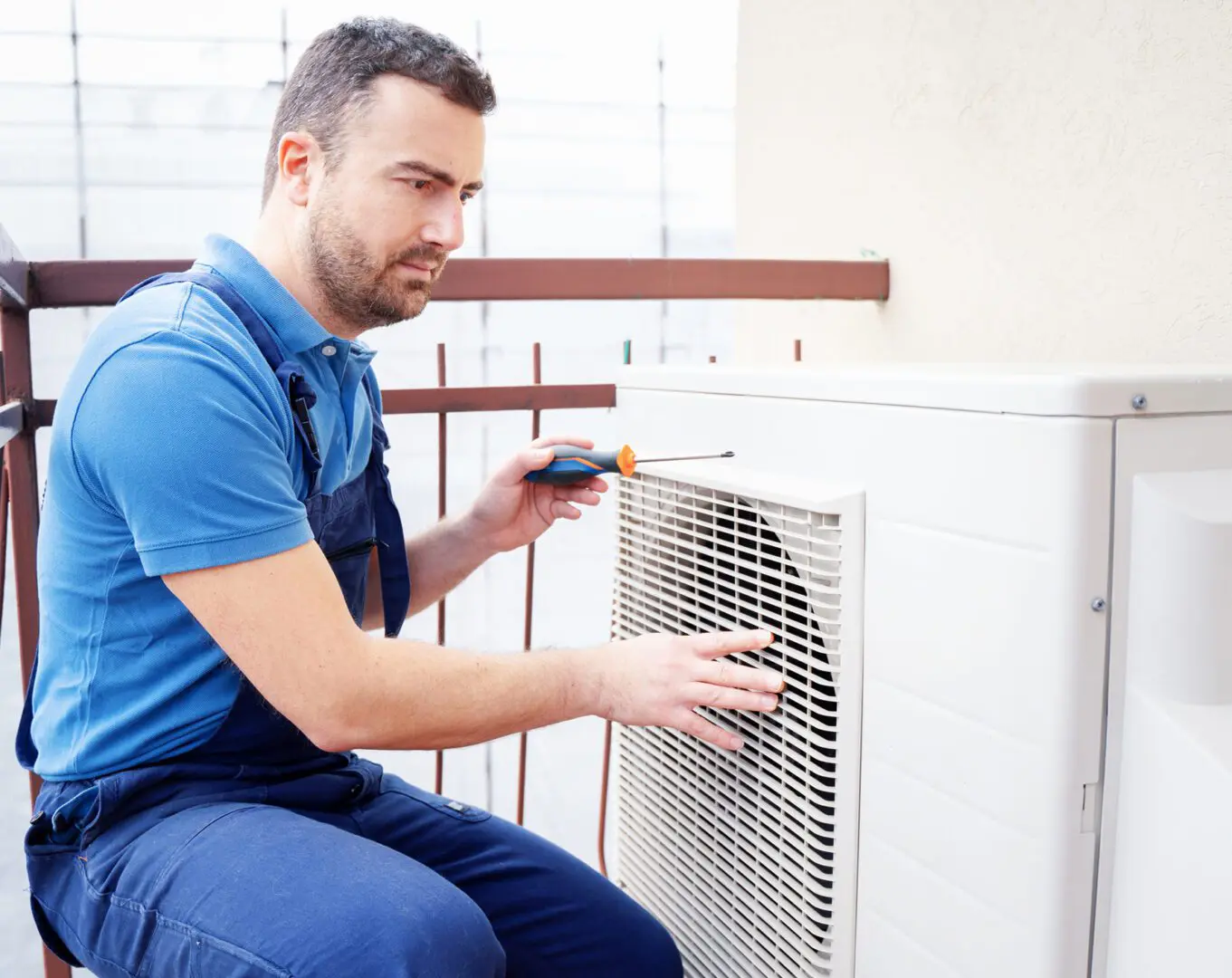 Technician repairing outdoor air conditioning unit.