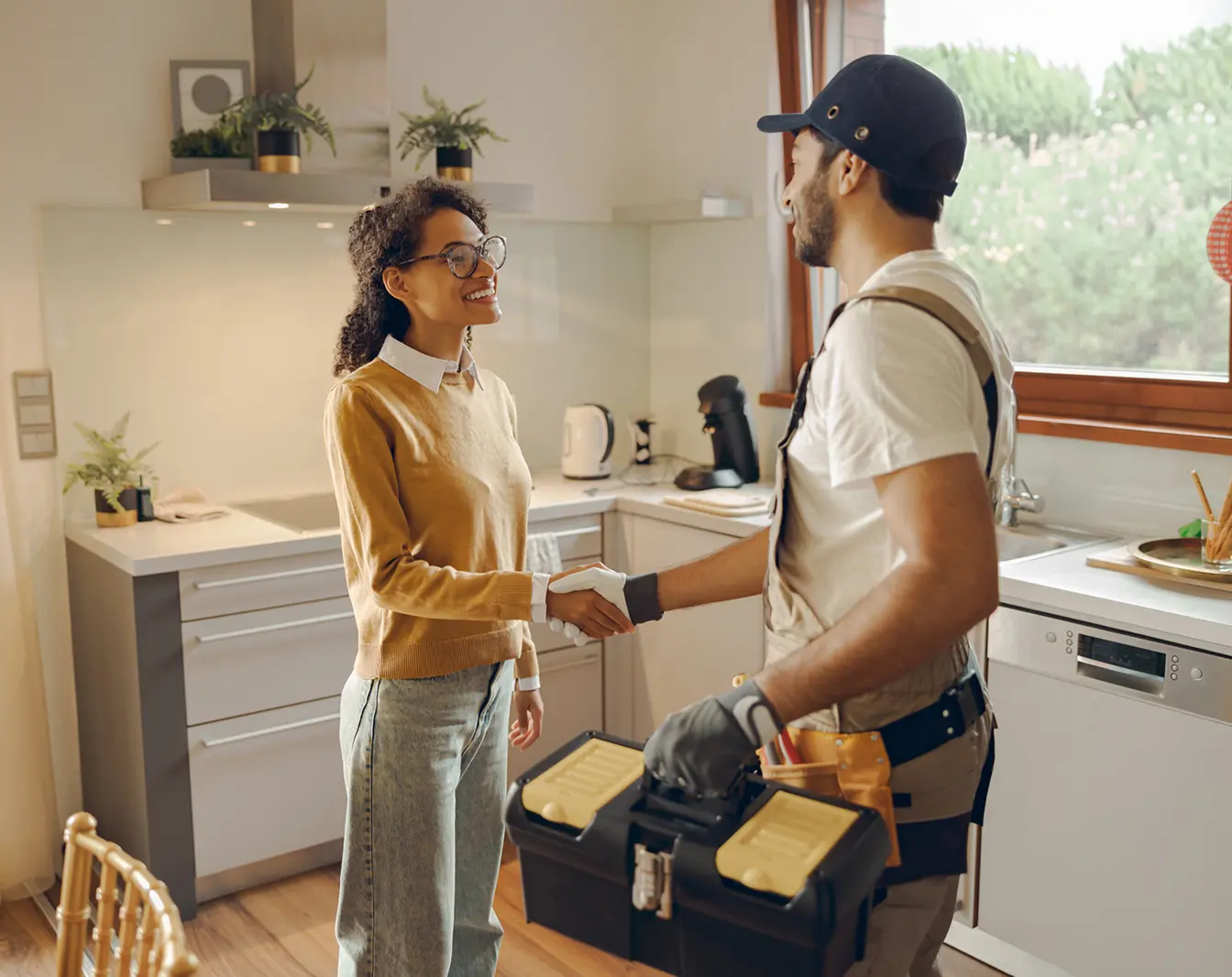 Woman shaking hands with a handyman.