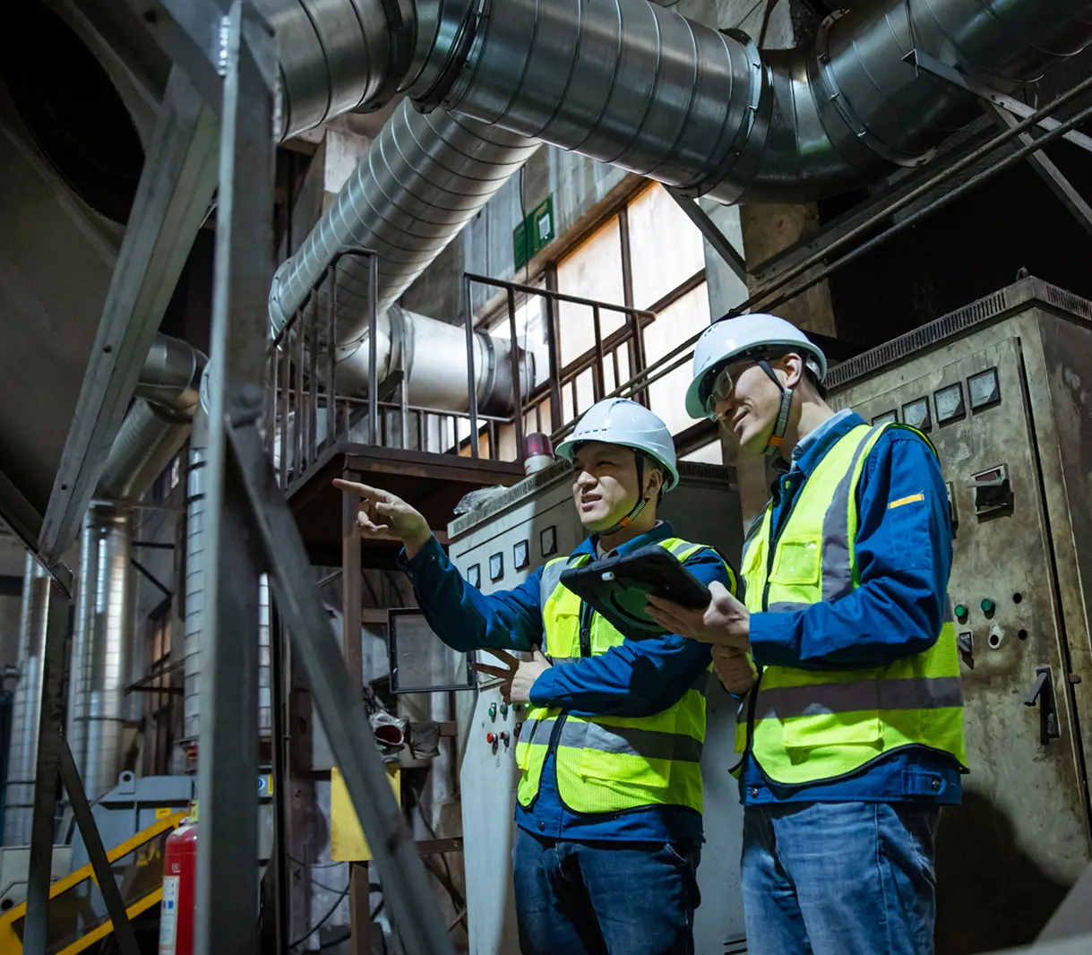 Engineers discussing work in industrial facility.