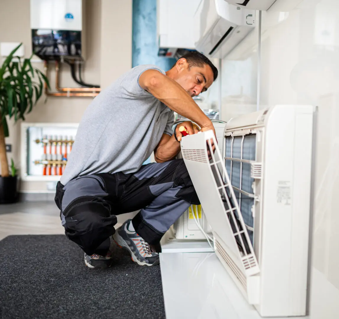 Technician repairing indoor air conditioning unit.