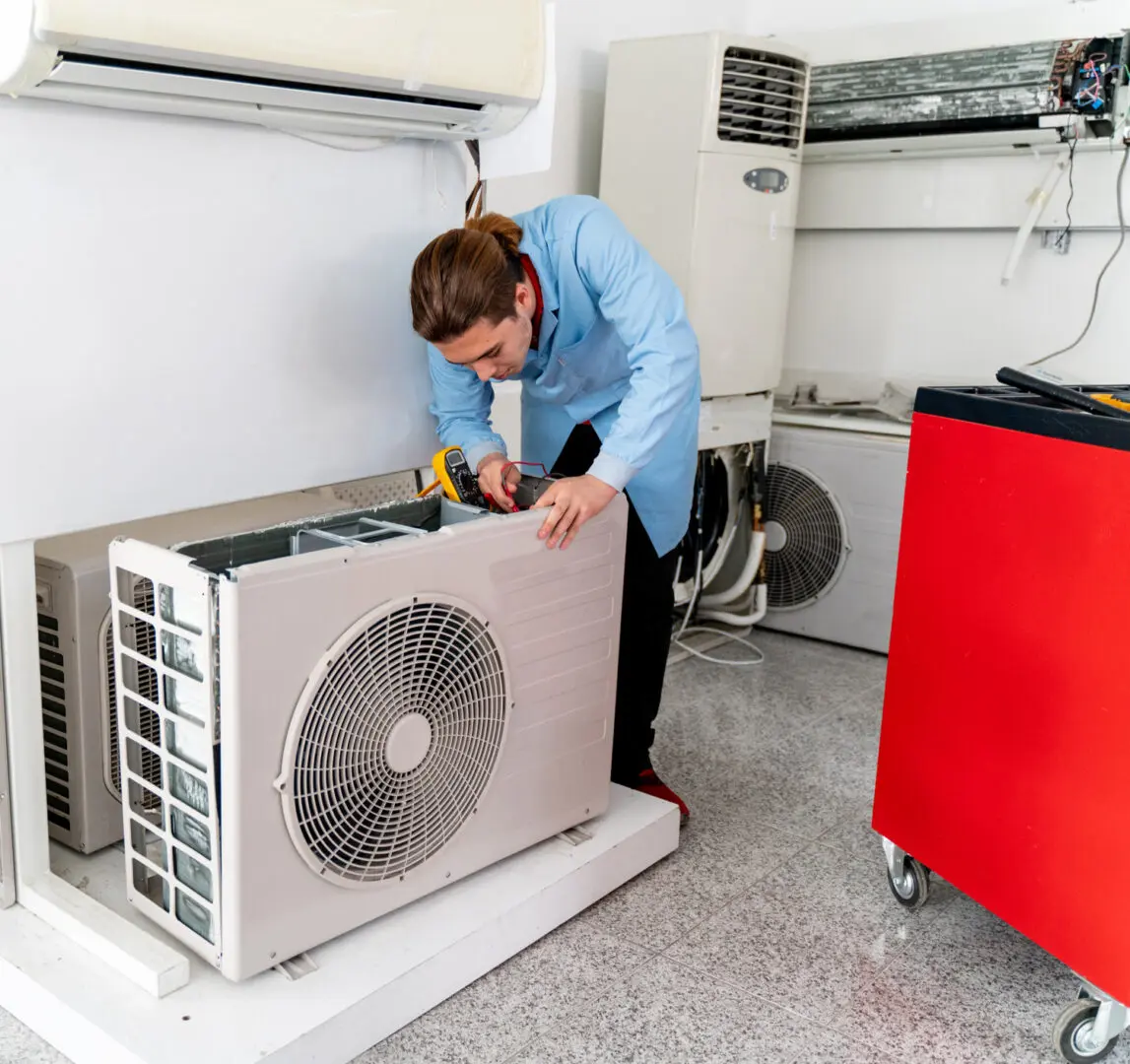 Technician repairing indoor air conditioning unit.