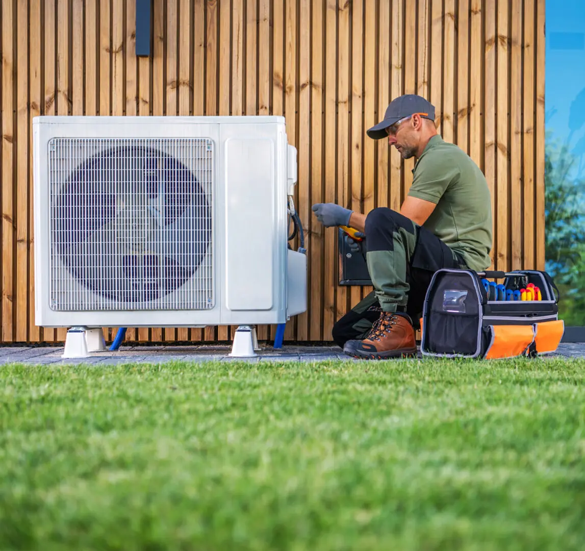 Technician repairing outdoor air conditioning unit.