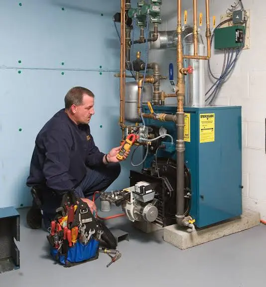 Technician using multimeter to test boiler