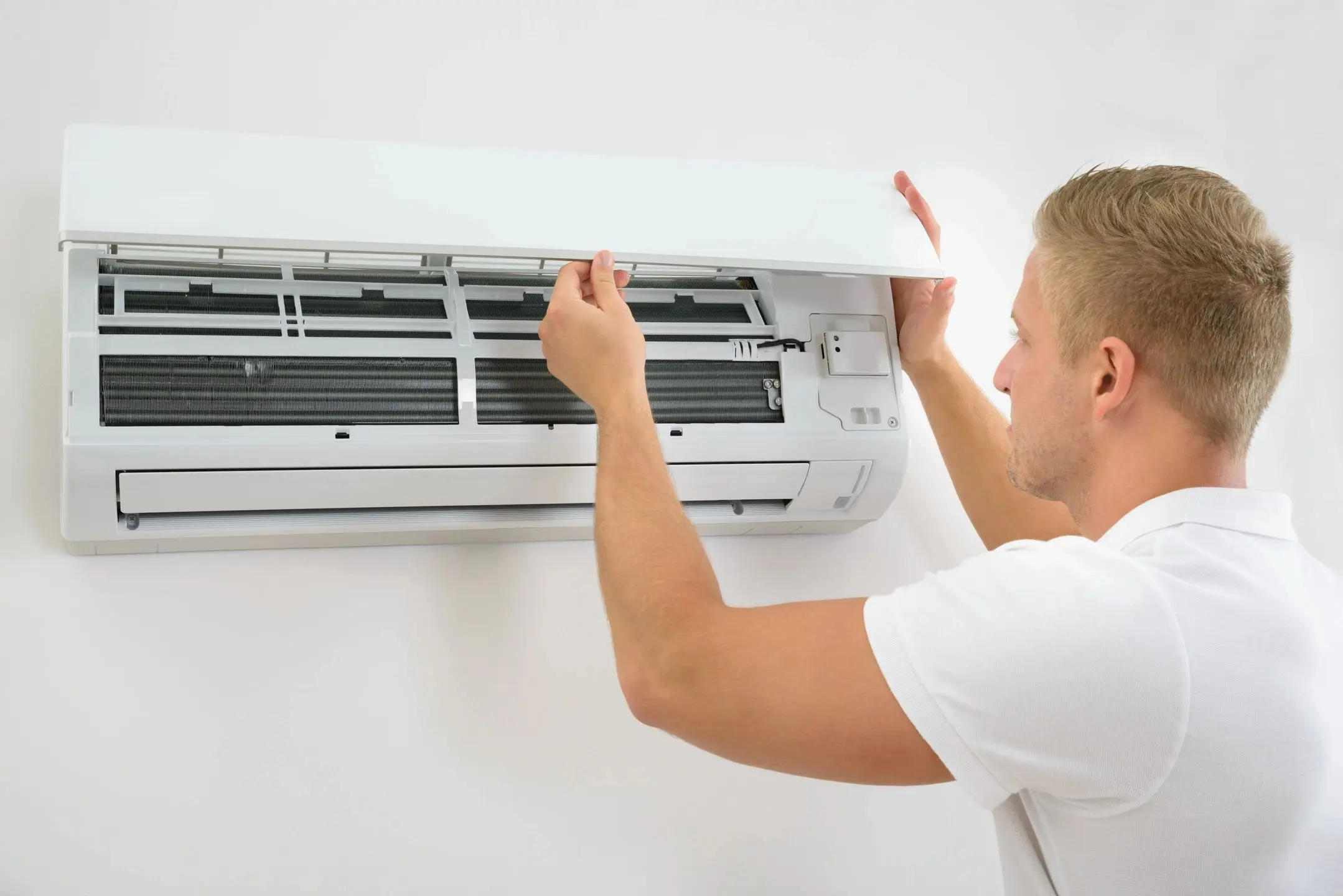 Technician cleaning wall-mounted air conditioner filter