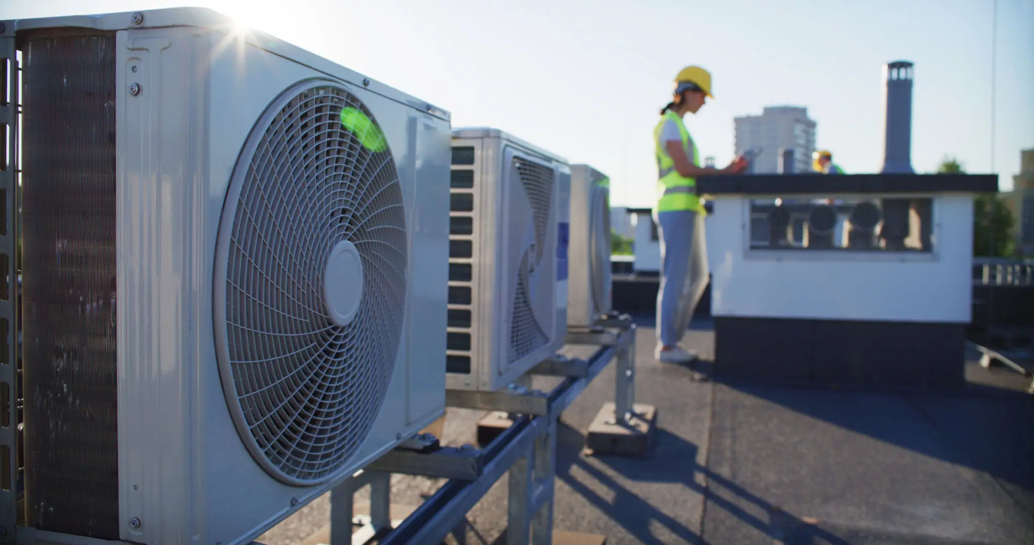 Technician inspecting rooftop HVAC units