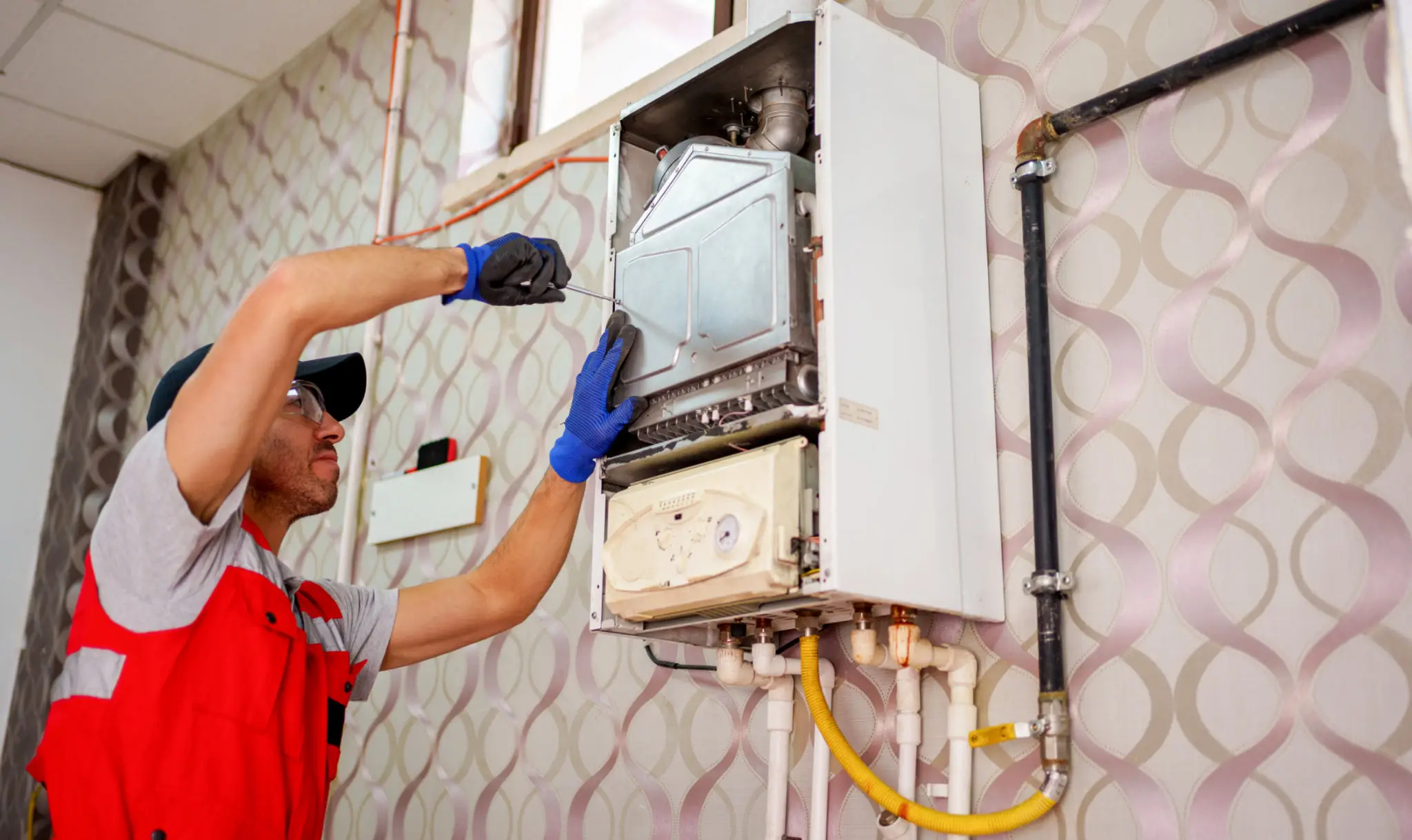 Technician repairing wall-mounted gas boiler