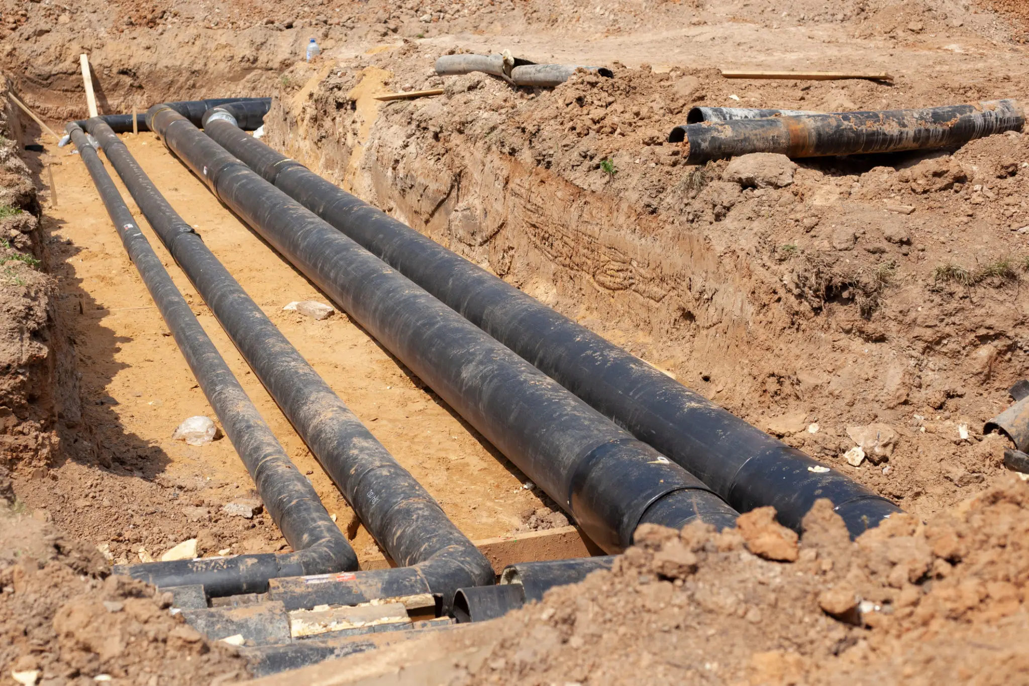 Underground black pipes laid in construction trench