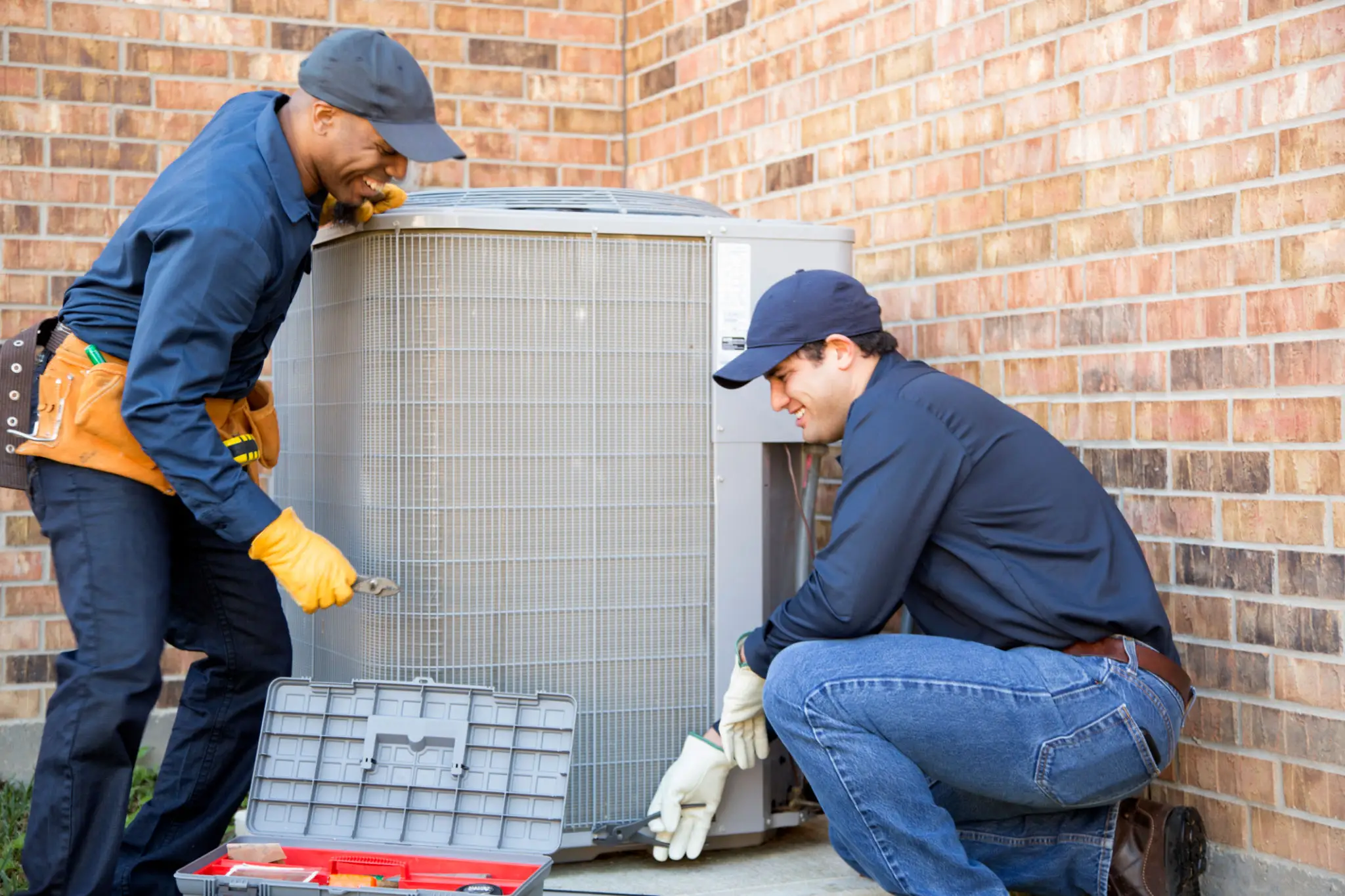 Technicians repairing outdoor air conditioning unit