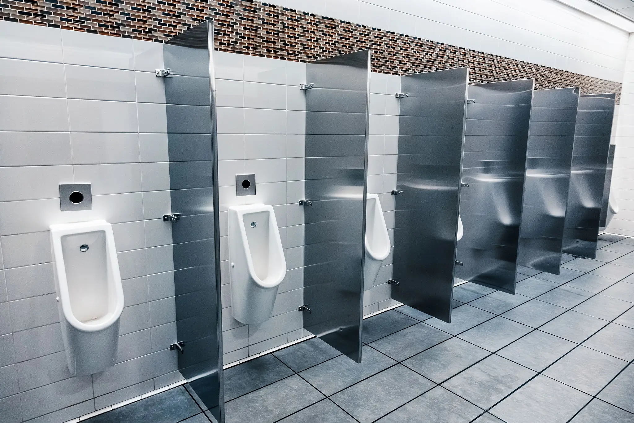 Public restroom urinals with stainless partitions
