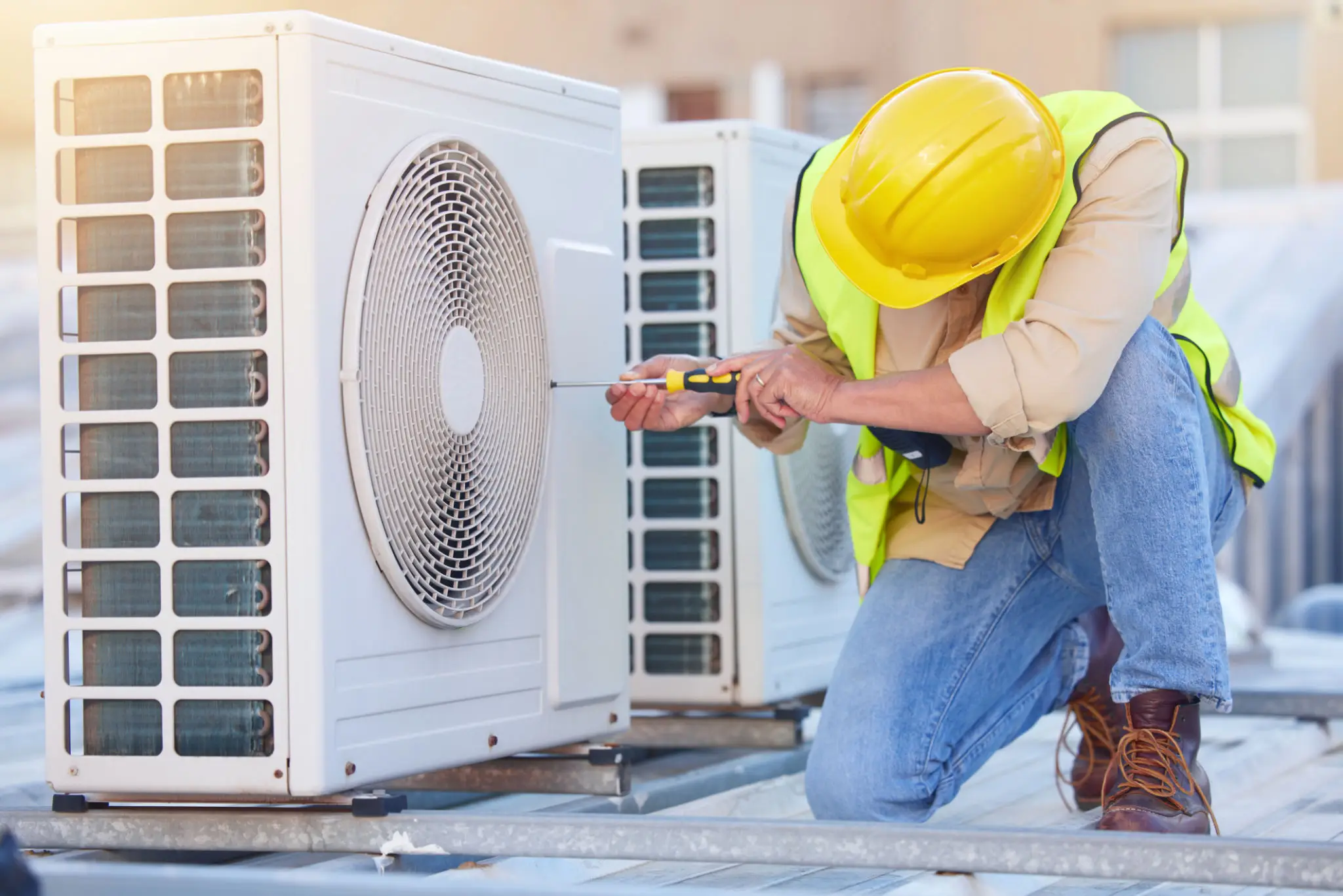 Technician repairing rooftop air conditioning unit