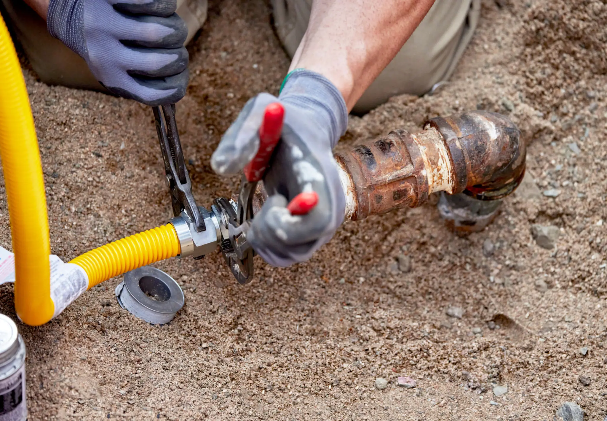 Plumber connecting yellow gas line to pipe