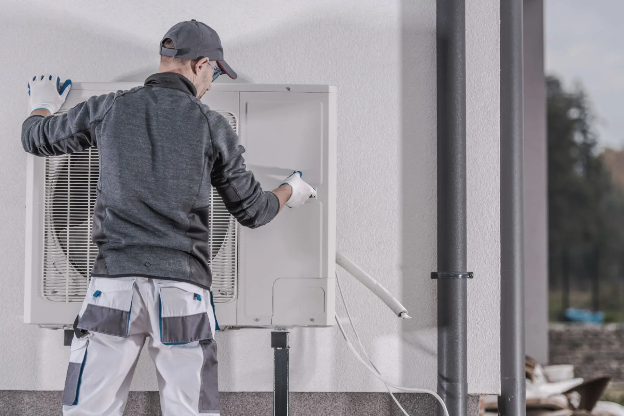 Technician installing outdoor HVAC unit