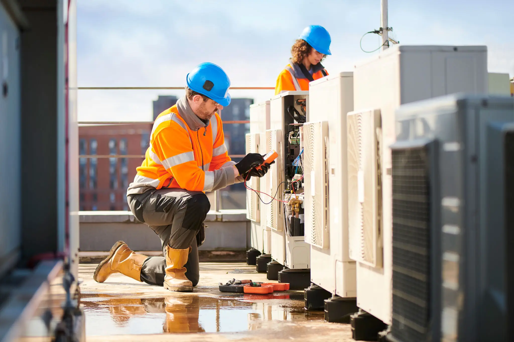 HVAC technicians repairing rooftop air conditioners